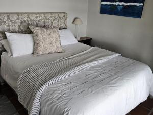 a bedroom with a large bed with white sheets and pillows at Ocean View Drive 150 in Struisbaai
