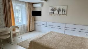 a bedroom with a bed and a table and a television at Okolytsia in Svitlovodsʼk