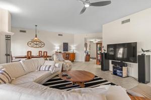 a living room with a couch and a tv at Coastal Serenity Spacious 3Br Condo In Minorca in New Smyrna Beach