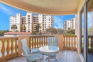 a patio with a table and chairs on a balcony at Coastal Serenity Spacious 3Br Condo In Minorca in New Smyrna Beach