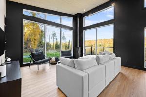 a living room with a white couch and large windows at Spa & Panoramic Nature Views - Alto in Saint Come