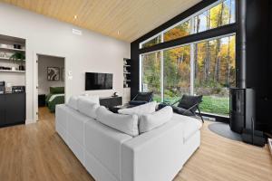 a living room with a white couch and a tv at Spa & Panoramic Nature Views - Alto in Saint Come