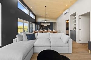 a living room with a white couch and a kitchen at Spa & Panoramic Nature Views - Alto in Saint Come
