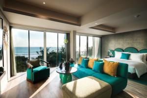 a bedroom with a blue couch and a bed with a view at MAMAKA Bali in Kuta