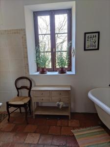 a bathroom with a tub and a window with potted plants at "Hertou" in Clèdes