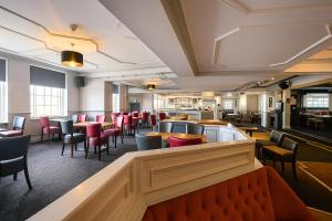a restaurant with tables and chairs and a bar at The Caledonian Tower Hotel in Blackpool