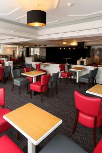a dining room with tables and red chairs at The Caledonian Tower Hotel in Blackpool