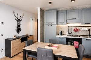 a kitchen and dining room with a wooden table at IL CERVO - 2 camere, garage Dolomiti Affitti in Cavalese