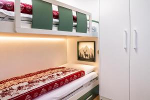 a small bedroom with a bunk bed and a ladder at IL CERVO - 2 camere, garage Dolomiti Affitti in Cavalese