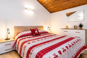 a bedroom with a bed with a red and white comforter at IL CERVO - 2 camere, garage Dolomiti Affitti in Cavalese