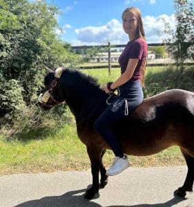 a young woman is sitting on a horse at Tiny Bauernhof Plau in Plau am See