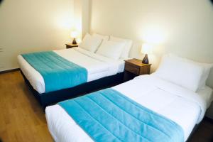 two beds sitting next to each other in a room at Haiken Hostal in Punta Arenas