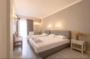 a bedroom with two beds and a chair at Mironi & Victoria in Limenas