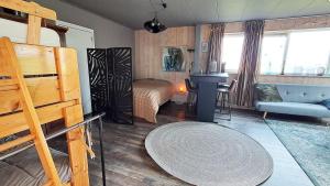 a living room with a couch and a table at Studio Rozenbottel shared bathroom in Hensbroek