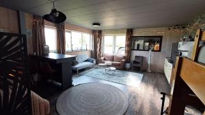 a living room with a couch and a table at Studio Rozenbottel shared bathroom in Hensbroek