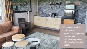 a living room with a couch and a table at Studio Rozenbottel shared bathroom in Hensbroek