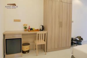 a wooden desk with a tv and a cupboard at Ella, Nine Arch Holiday Resort in Ella