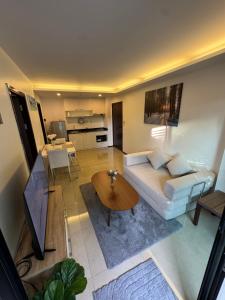 a living room with a white couch and a table at The Title Rawai in Ban Saiyuan (1)