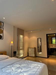 a bedroom with a large bed and a bathroom at The Title Rawai in Ban Saiyuan (1)