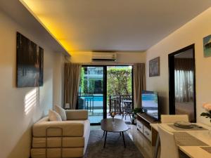 a living room with a couch and a tv at The Title Rawai in Ban Saiyuan (1)