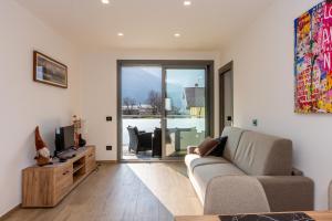 a living room with a couch and a tv at La Strencia in Villa di Tirano