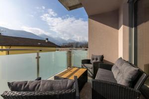 a balcony with chairs and a table and a view at La Strencia in Villa di Tirano