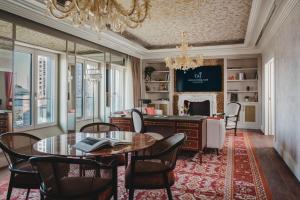 a dining room with a table and chairs and a desk at Taj Hessischer Hof Frankfurt in Frankfurt