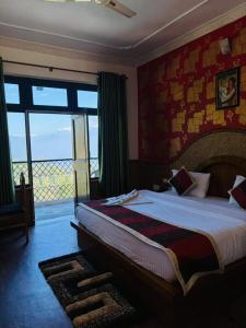 a bedroom with a large bed and a balcony at Hotel Sumit in Kausani +14 photos