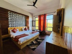 a bedroom with a bed and a large window at Hotel Sumit in Kausani