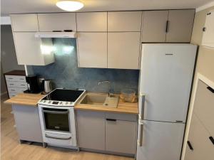 a kitchen with white cabinets and a white refrigerator at Hybel in Porsgrunn