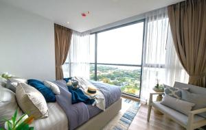 a bedroom with a bed and a large window at Andromeda Condominium Pattaya in Pattaya South