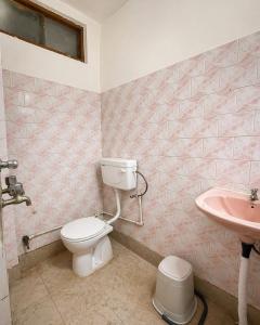 a bathroom with a toilet and a sink at Hotel Ramya Palace in Gwalior