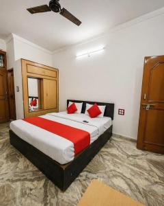 a bedroom with a large bed with red pillows at Hotel Ramya Palace in Gwalior