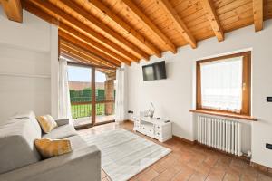 a living room with a couch and a large window at Villa Luna Appartements und Spa in Calmasino