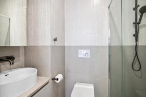 a bathroom with a shower and a toilet and a sink at Chic Home with BBQ & Outdoor Dining in Carnegie