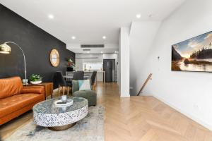 a living room with a couch and a table at Chic Home with BBQ & Outdoor Dining in Carnegie