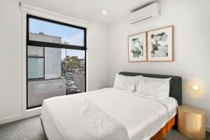 a bedroom with a bed and a window at Chic Home with BBQ & Outdoor Dining in Carnegie