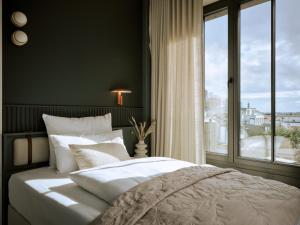 a bedroom with a bed and a large window at THE SHORELINE Sellin in Ostseebad Sellin +56 photos