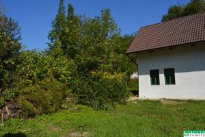 a white house with green windows on the side of it at Chalúpka na Podkylave in Podkylava