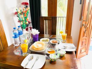 a table with plates of food and drinks on it at Lethi Family Villa in Negombo