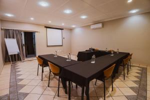 a meeting room with two tables and chairs and a screen at Greenfields Guesthouse & Restaurant in Alberton +232 photos