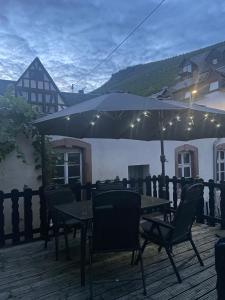 a table and chairs under an umbrella on a deck at Haus Janne in Zell an der Mosel