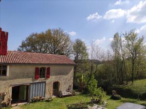 an old stone house with red shutters on a field at "Hertou" in Clèdes