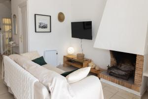 a living room with a white couch and a fireplace at Baconer - Casa en l'Ampolla con jardín privado y acceso directo al mar - Deltavacaciones in L'Ampolla
