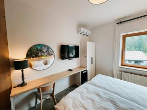 a bedroom with a bed and a mirror and a desk at Hotel Oskar Zaplata in Preddvor