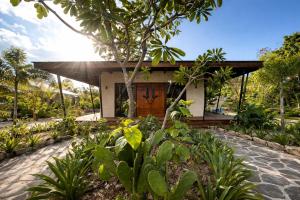 a house with a wooden door in a garden at Serenity Sands Island Glamping in Bounty Island