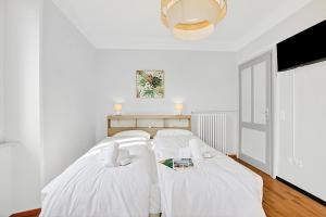 two beds in a room with white walls at Rooms in Villa Agra in Agra