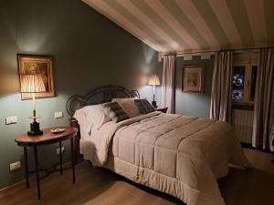 a bedroom with a bed and a table and two lamps at La Dimora di Luca in Bientina