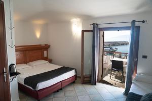 a bedroom with a bed and a door to a balcony at Il Nuovo Gabbiano in Cala Gonone