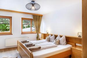 a bedroom with a bed with white sheets and pillows at Aparthotel Sonnblick in Kartitsch